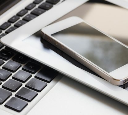 Phone and Tablet laying on a laptop